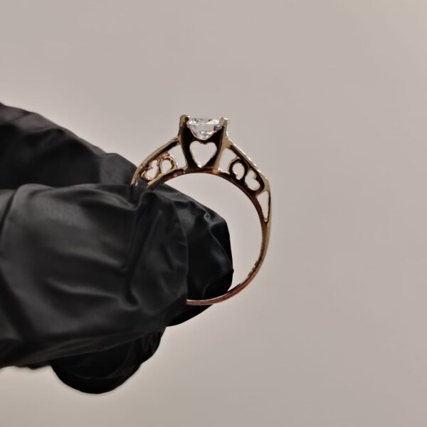 Anillo de plata con piedra preciosa grande y piedras pequeñas incrustadas con detalle de corazones